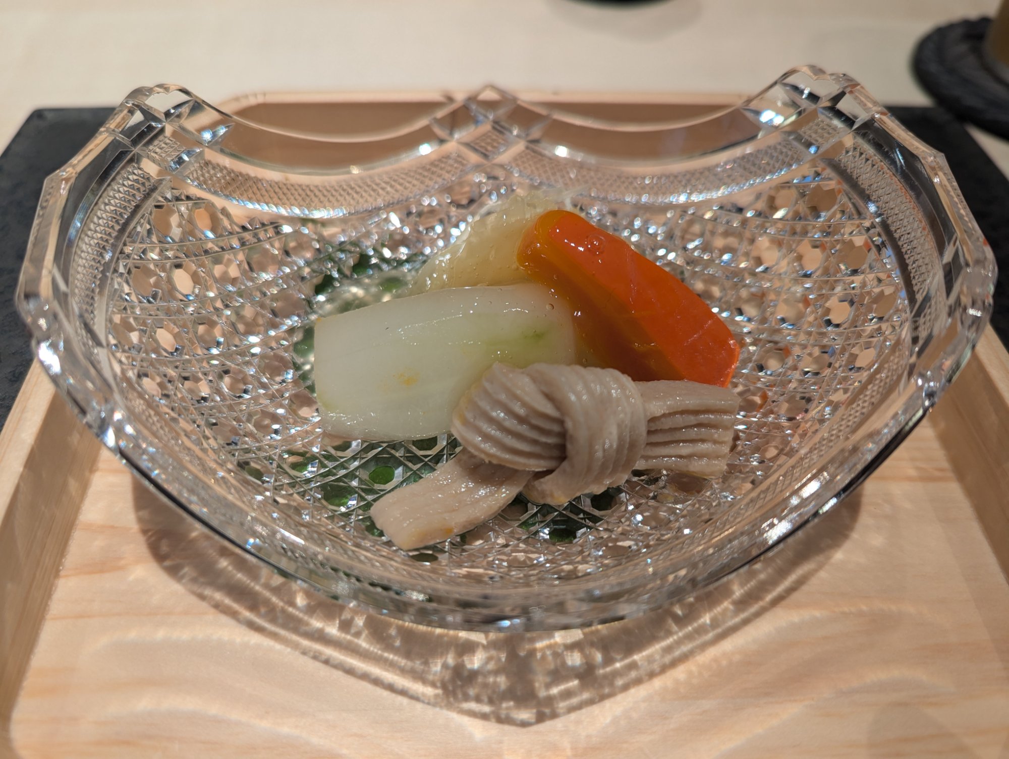 Chilled Kaga vegetables in a large cut-crystal bowl, the vegetable colors illuminated by the glass
