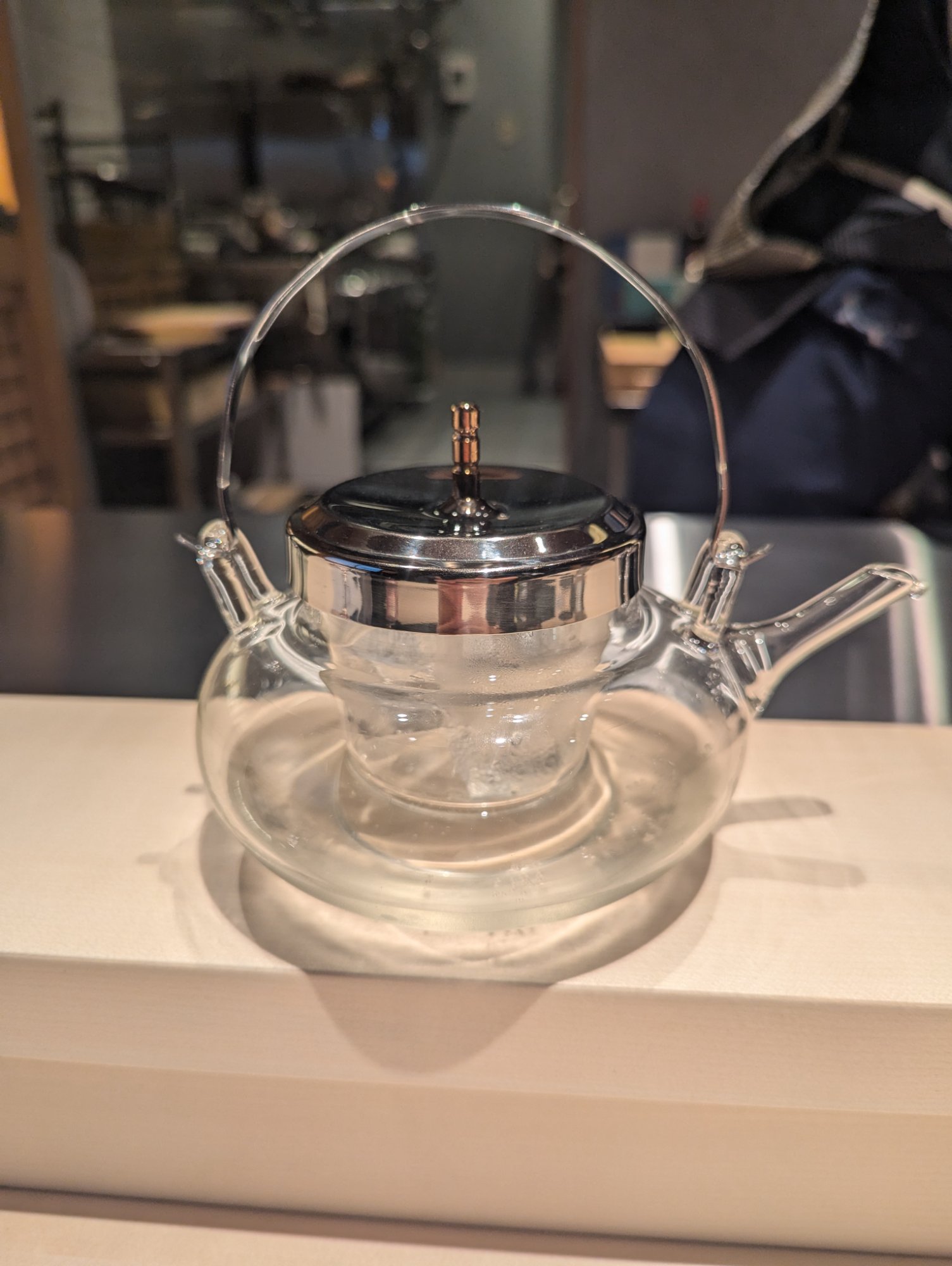 Domestic black tea in a glass teapot, the leaves opening in the amber liquid