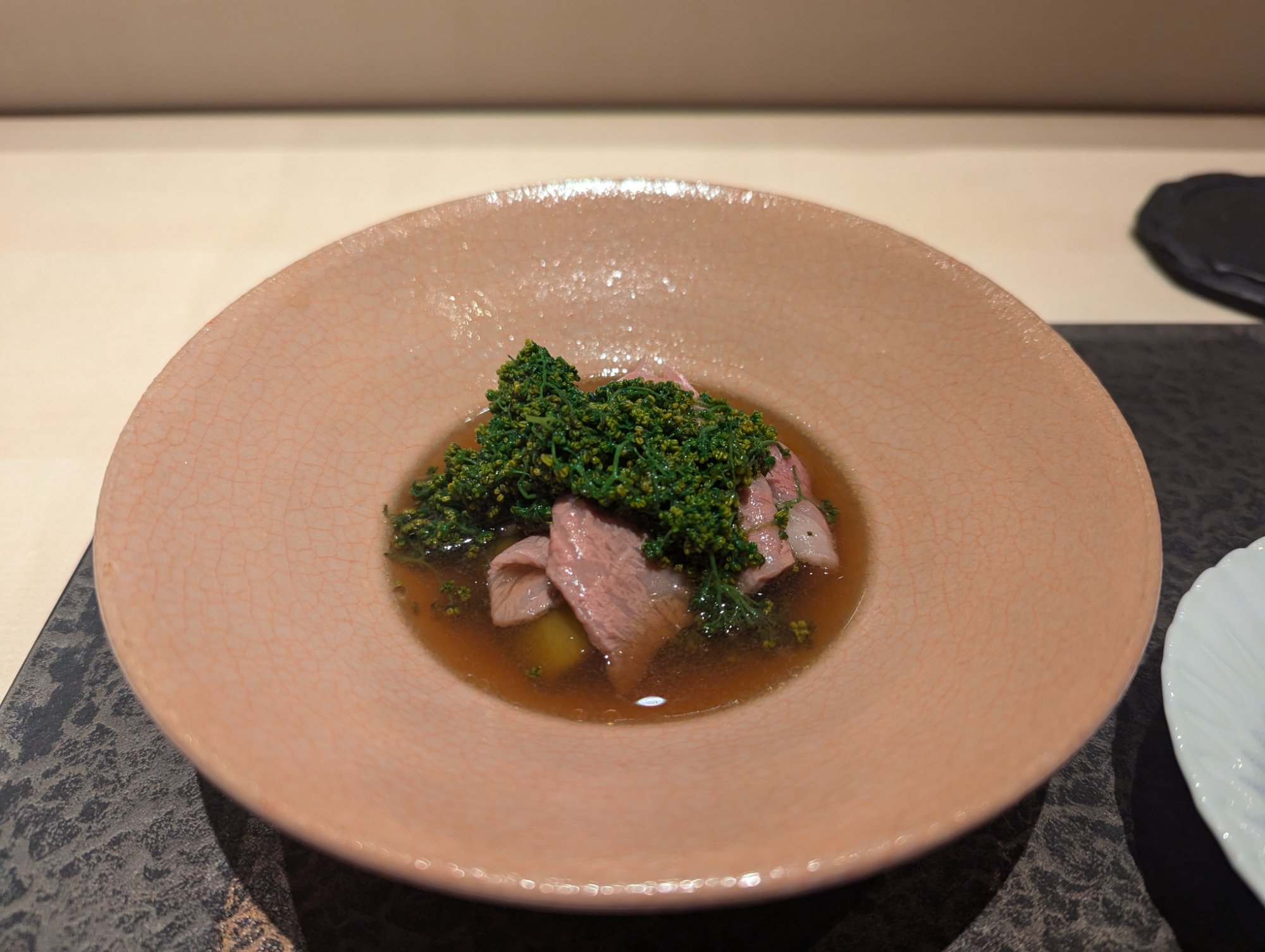 Furano Wagyu hanasansho hotpot. The cooked meat with abundant flower pepper, served in a pale pink vessel